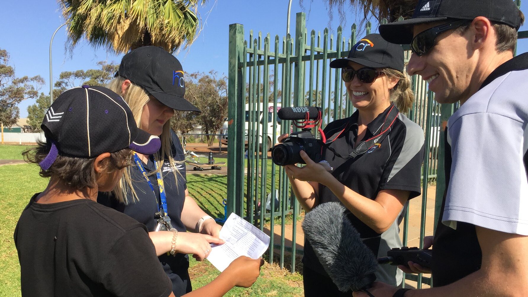 two HCR workers help young people to do a media project