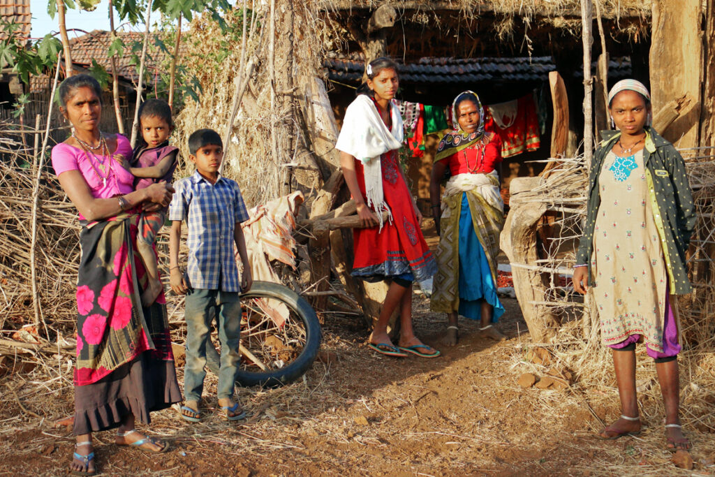 Adivasi family outside hut in Maharashtra