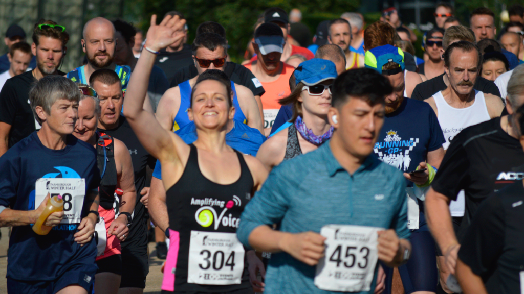 Amy Hargreaves waves at the camera just after the buzzer sounds to begin the Farnborough Winter Half Marathon
