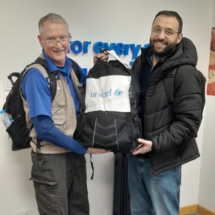 2 men holding a backpack radio station for Gaza